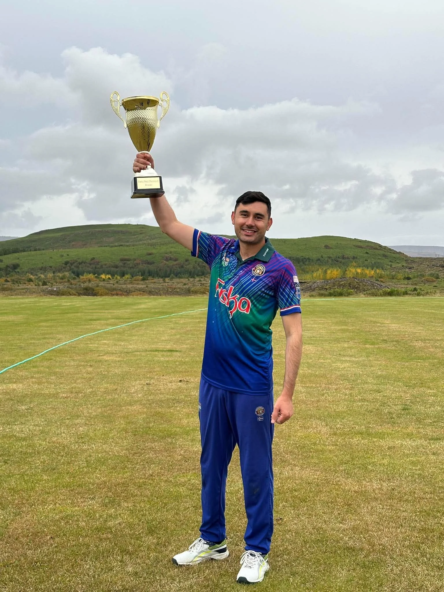 A Kópavogur Puffins player lifts the 2026 Sixty Ball Shootout trophy