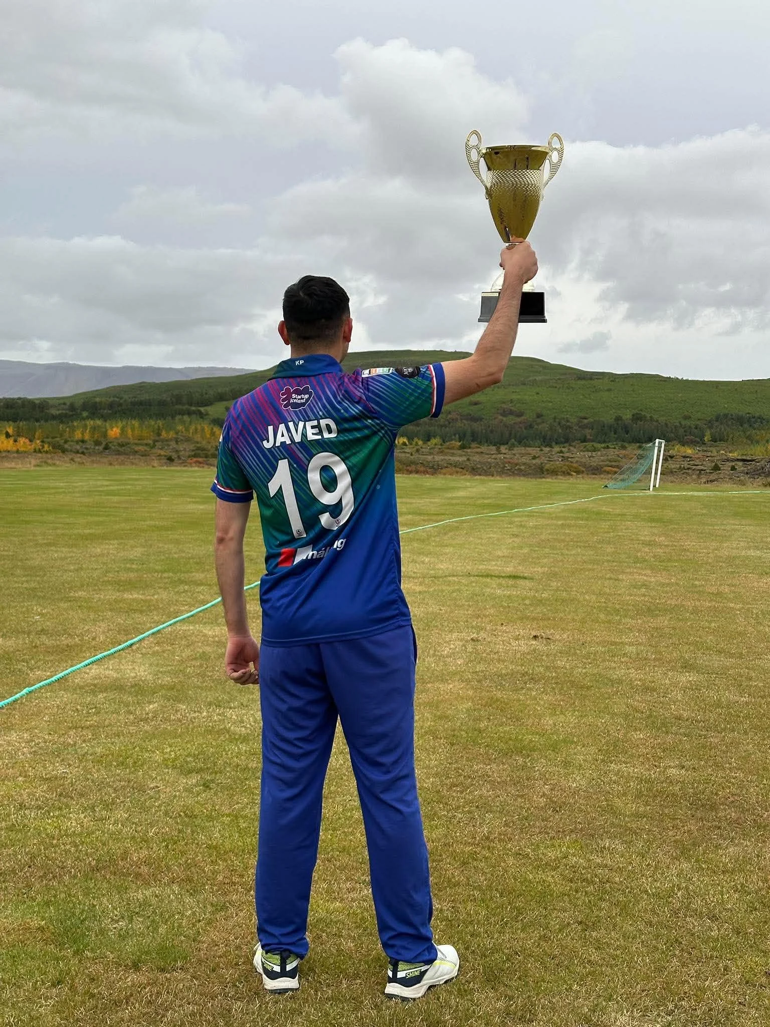 A Puffins player wearing the Javed 19 jersey raises the T10 trophy